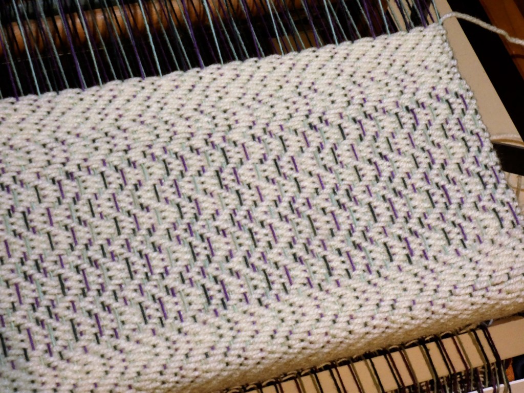 Creating a sampler with the existing warp. The white yarn is scrap acrylic.
